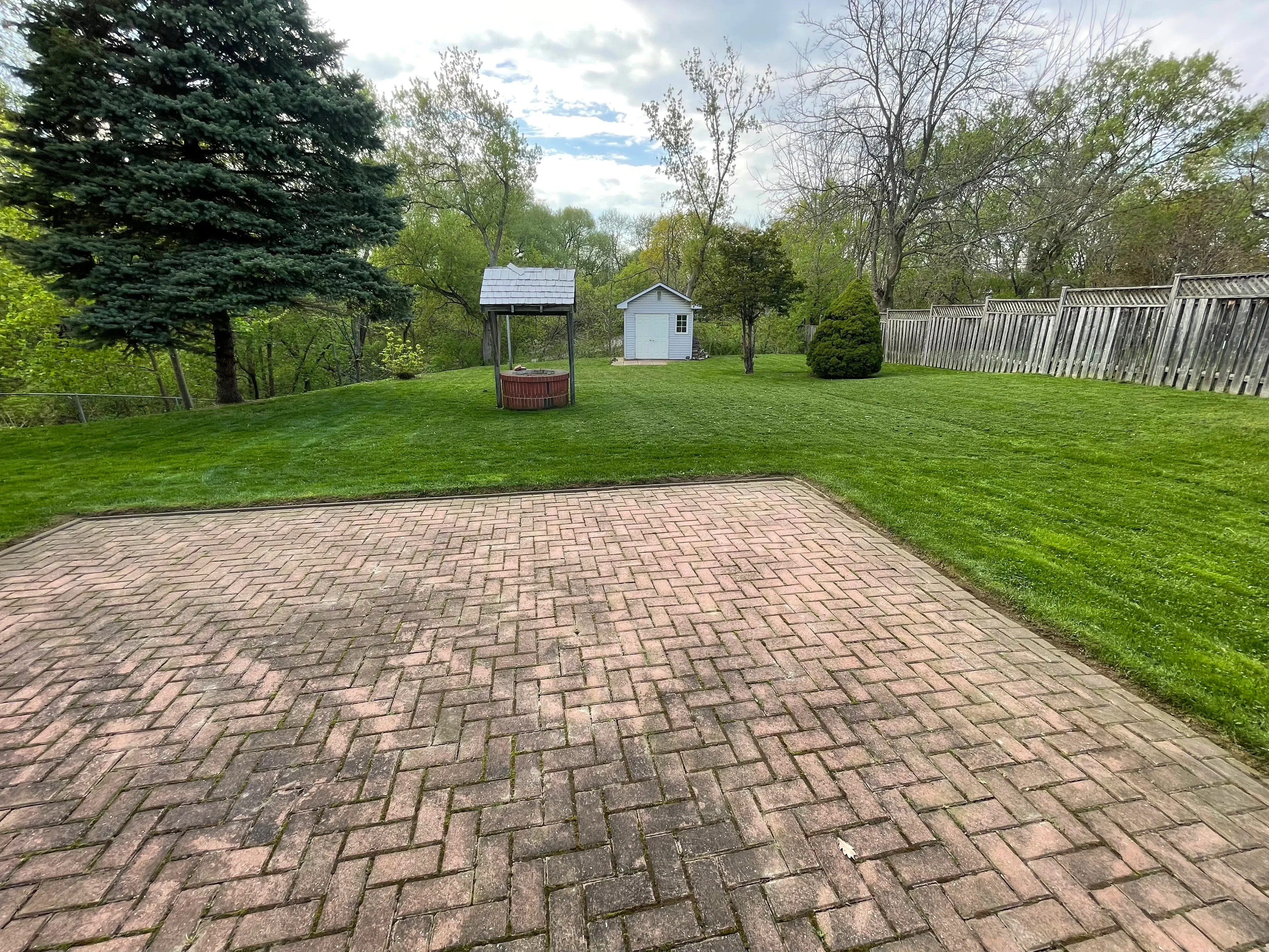 Professional landscaping work showing a beautiful patio and lawn maintenance by KCG Outdoor Services